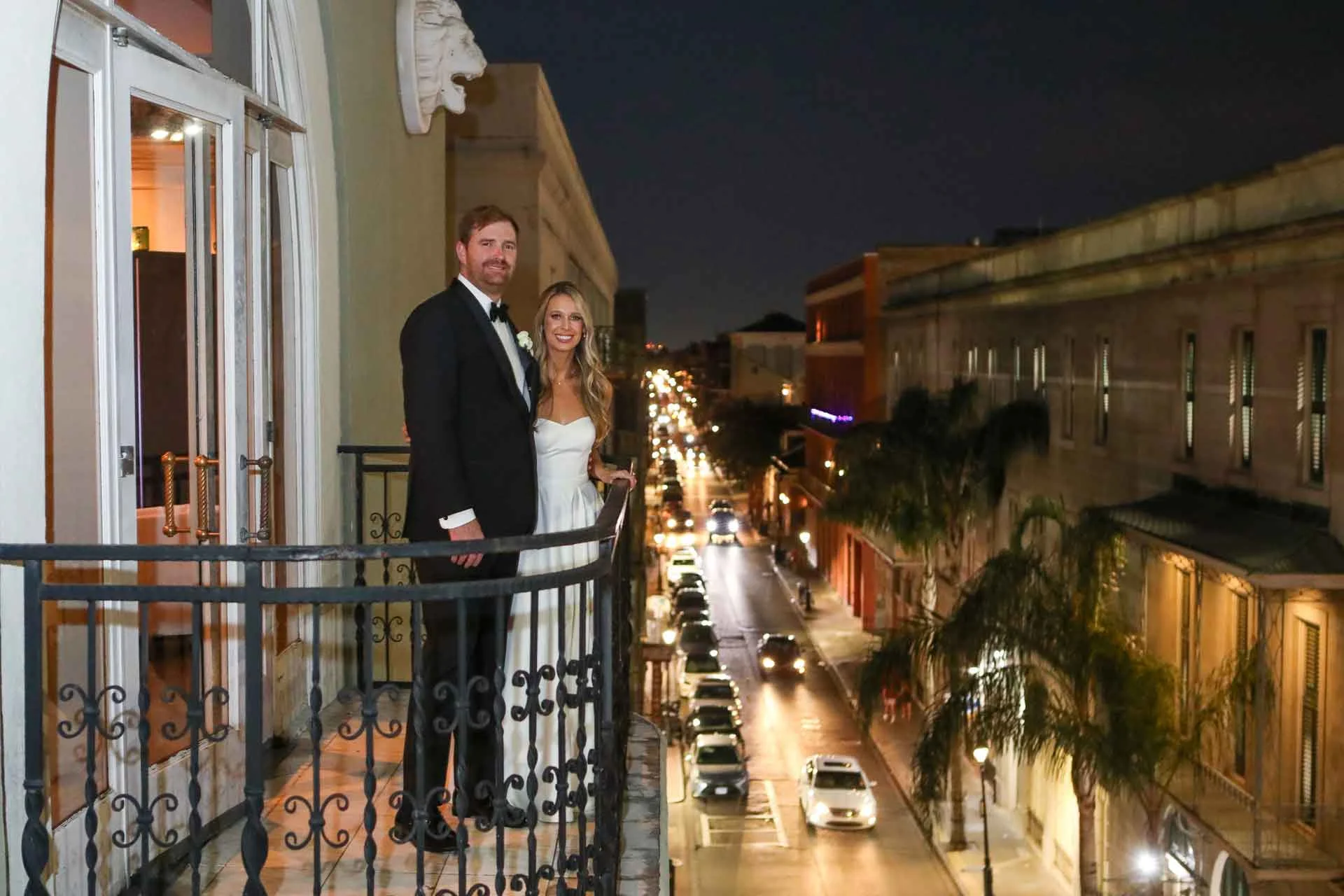 Newlywed couple on balcony looking over streets in New Orleans, LA